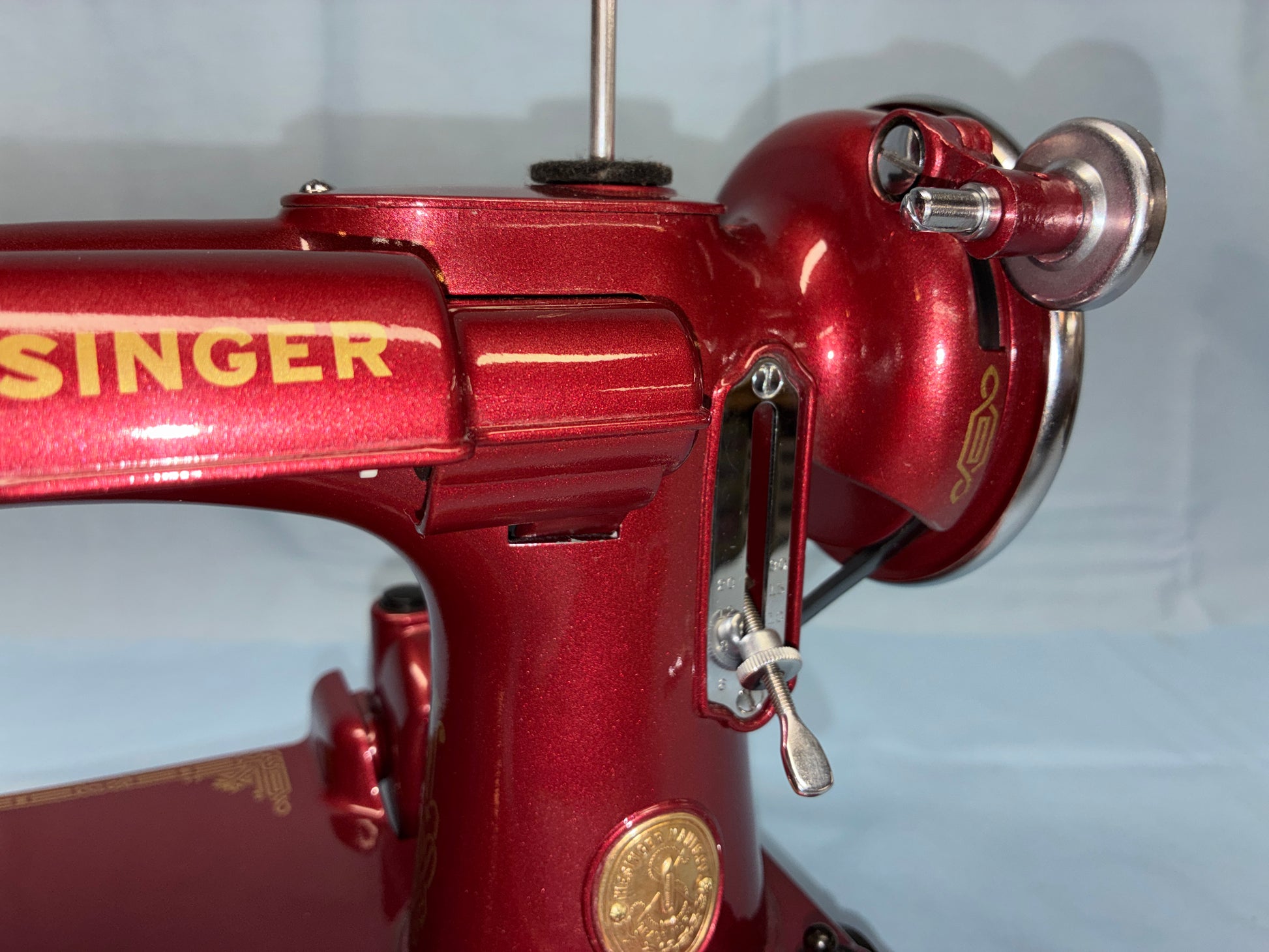 Red Singer sewing machine with gold accents on a white background
