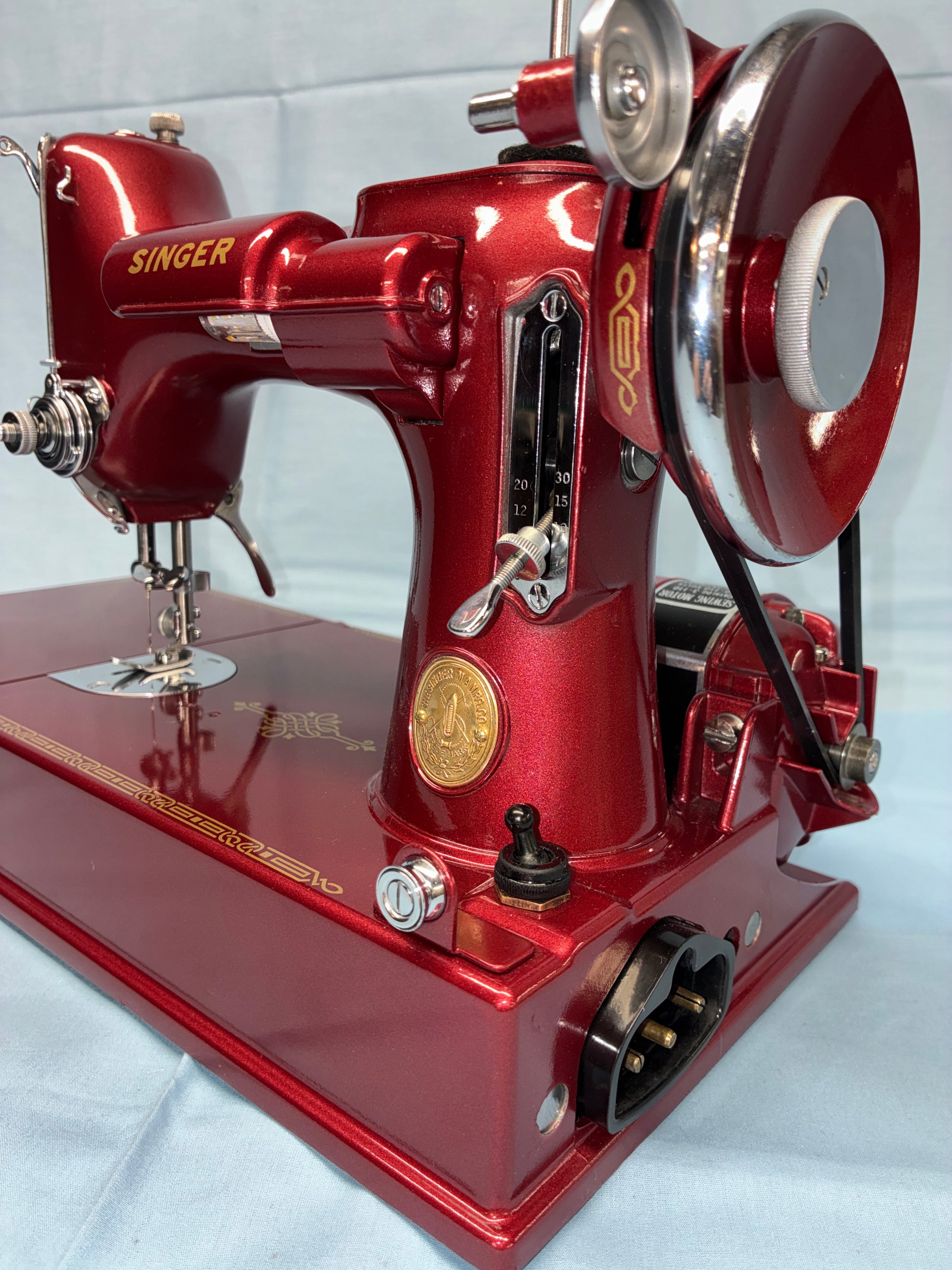 Red sewing machine with gold accents on a white background